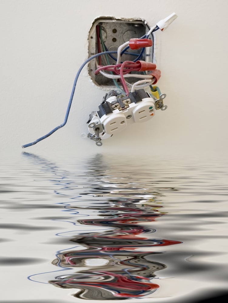 Electrical outlet reflected in floodwater in office