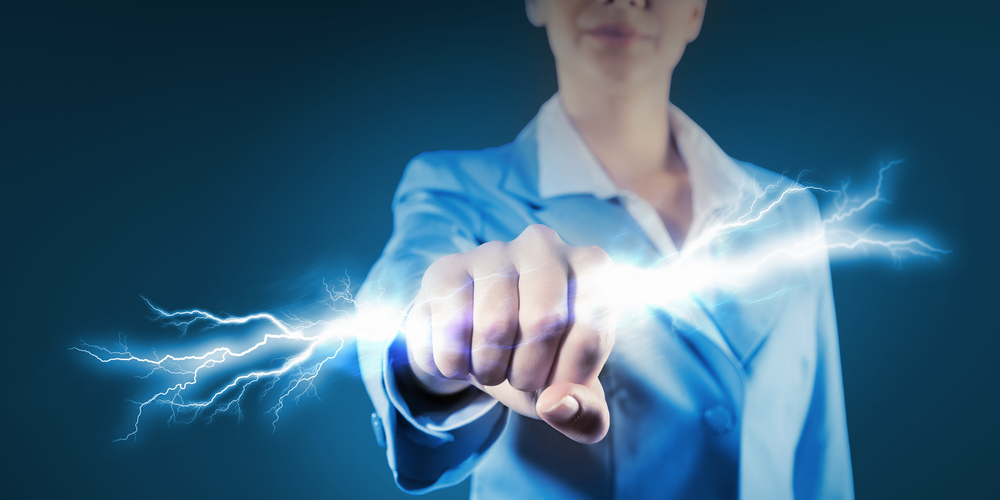 Image of powerful businesswoman holding lightning in fist